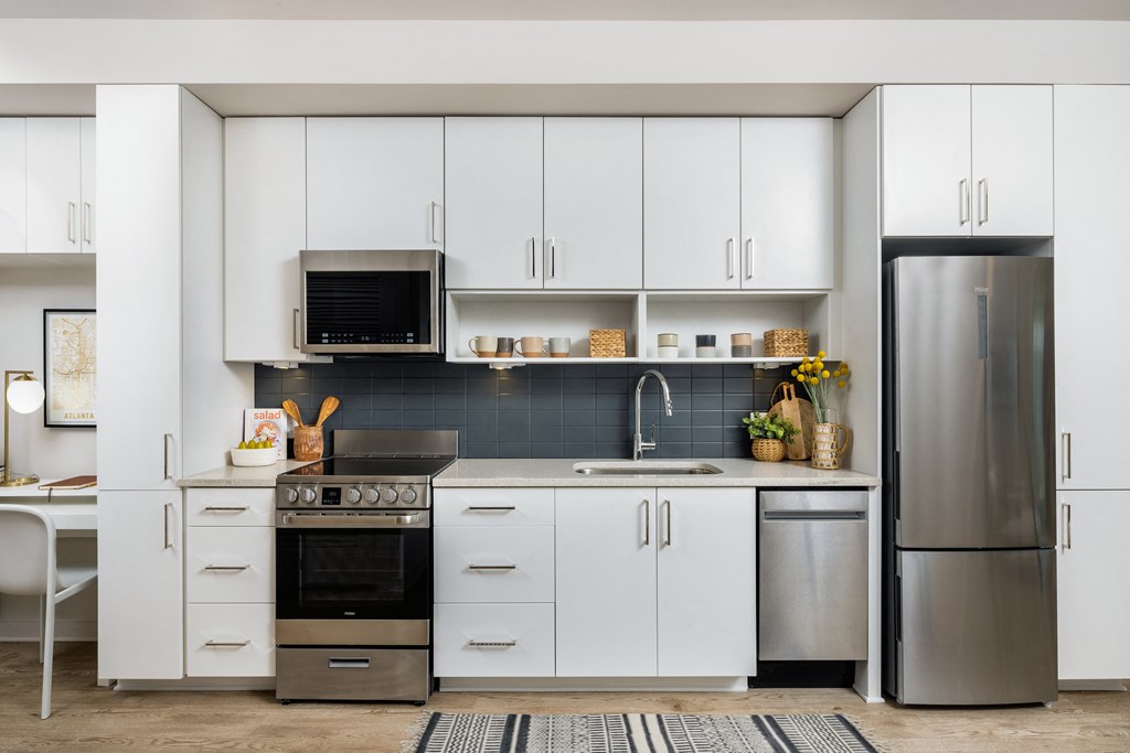 a kitchen with white cabinets and stainless steel appliances
