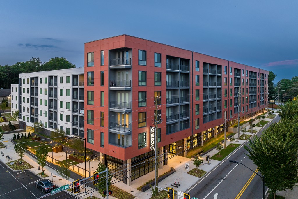 an aerial view of a red and white apartment building on a city street