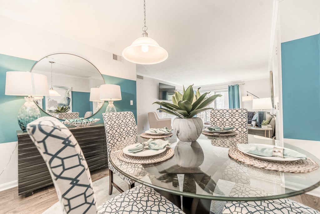 a dining room with a glass table and chairs