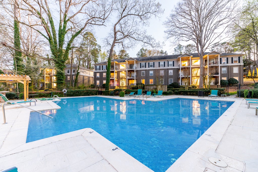 a swimming pool with an apartment building in the background