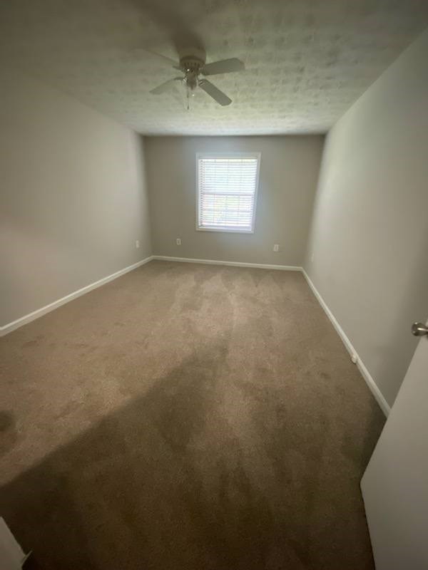 A room with a ceiling fan and a window.
