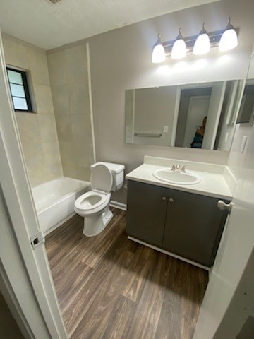 A bathroom with a toilet, sink and mirror.