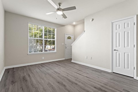 a long hallway with white doors and a ceiling fan