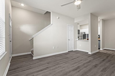 a living room with white walls and a ceiling fan