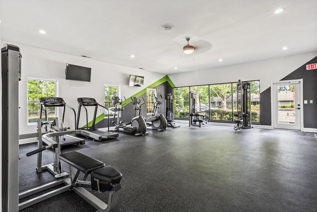 the gym has plenty of cardio equipment and glass doors to the backyard