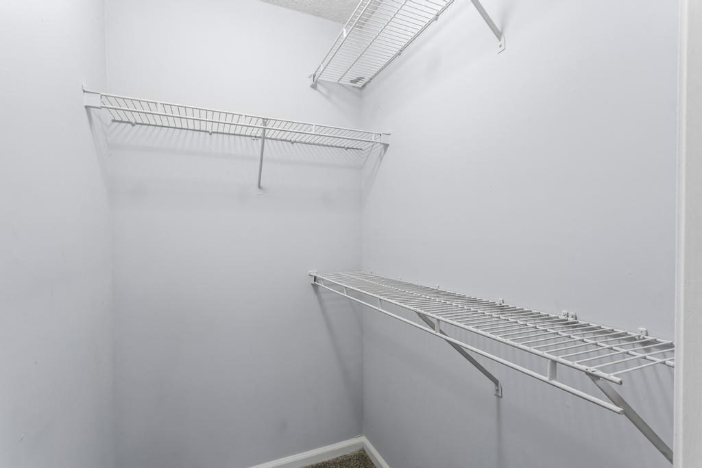 a white closet with an empty shelf on the wall