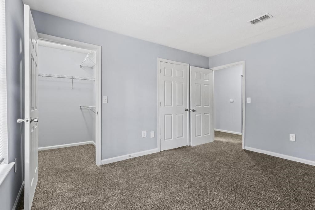 a bedroom with two closets and a door to a closet