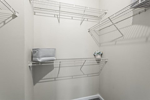 a walk in closet with shelves and hooks on the wall