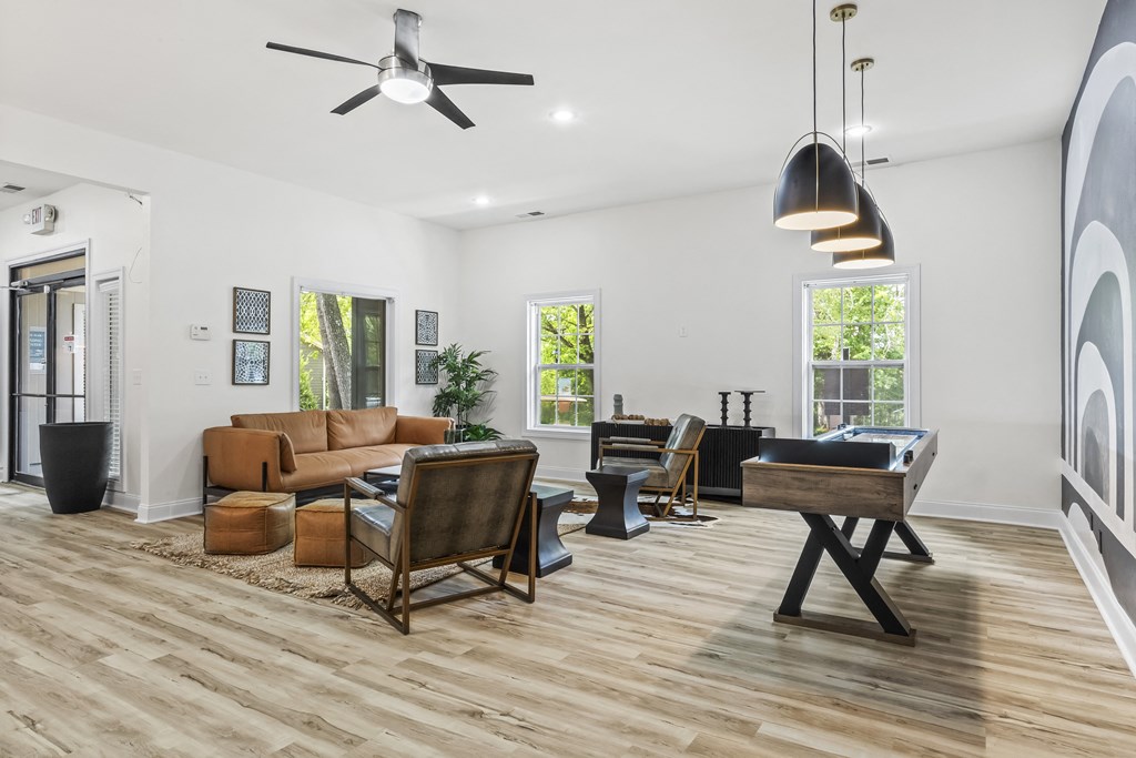 a living room with a couch and chairs and a pool table