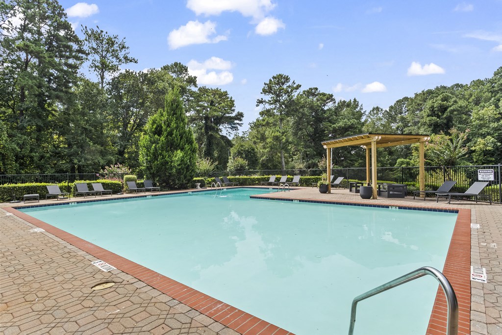 a swimming pool with trees in the background