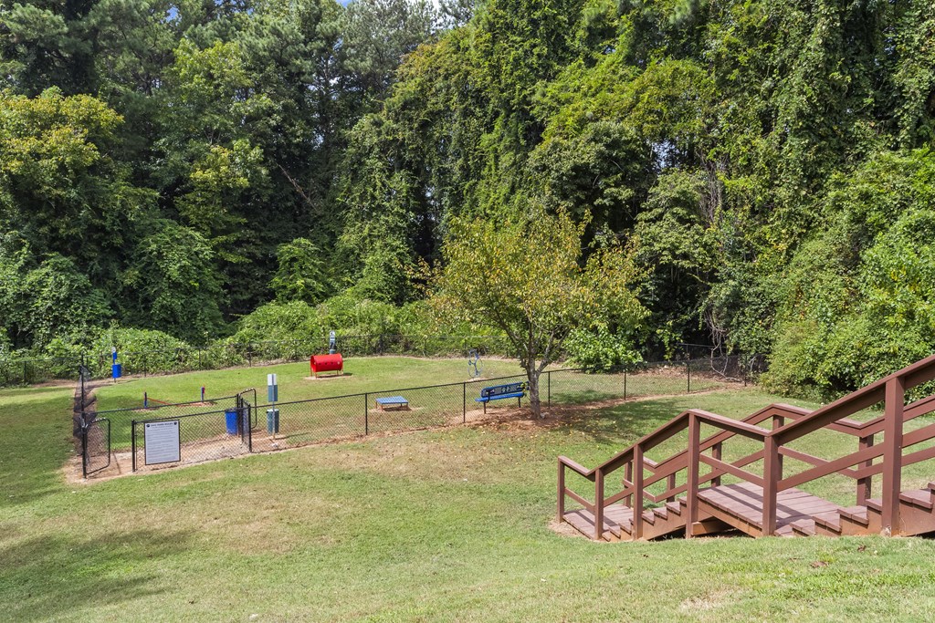 a park with benches and a chain link fence