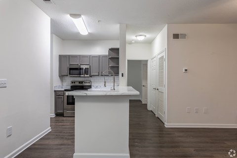 A kitchen with a white island in the middle of the room.