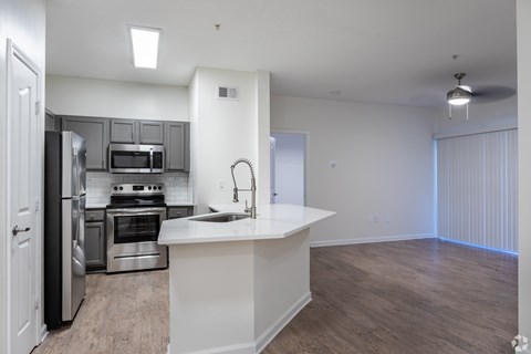 A kitchen with a white countertop and stainless steel appliances.