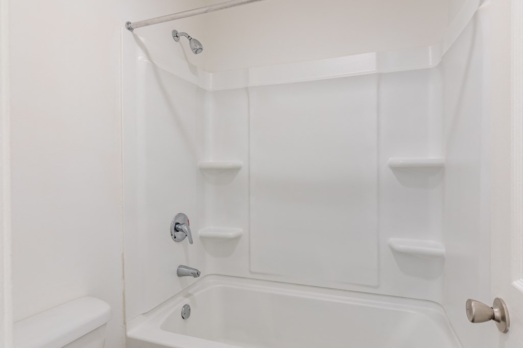 a white bathroom with a tub and a sink and a toilet