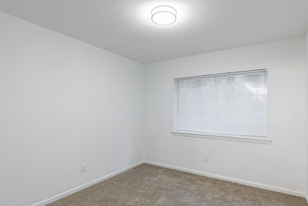 an empty room with white walls and a window