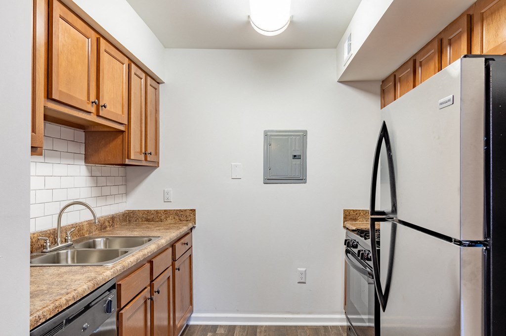 an empty kitchen with a sink and a refrigerator