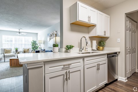 A kitchen with white cabinets and a sink.