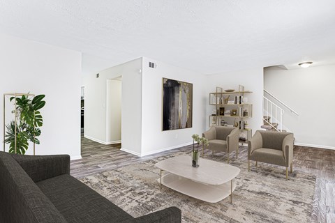 A living room with a grey couch, a coffee table, and a painting on the wall.