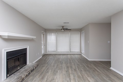 A room with a fireplace and wood flooring.