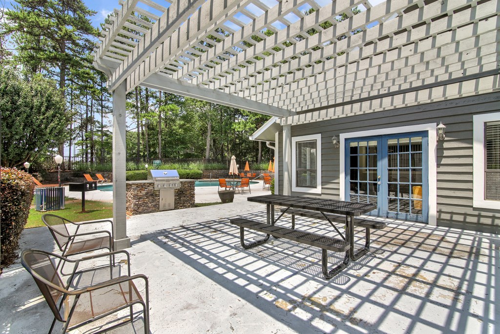 A patio with a table and chairs under a pergola.
