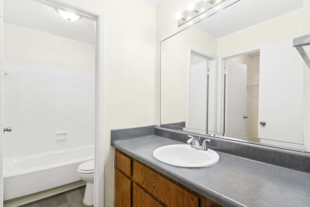 A bathroom with a white sink and a white toilet.