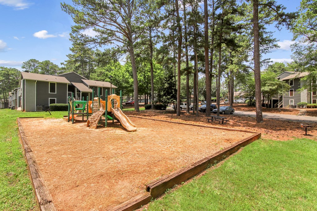 A playground with a slide and a wooden fence.