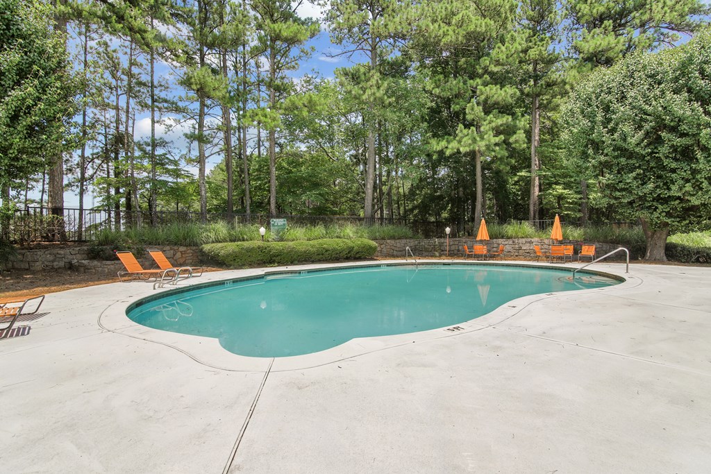 A swimming pool surrounded by orange cones and trees.