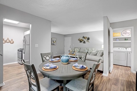 A dining room with a table set for four.