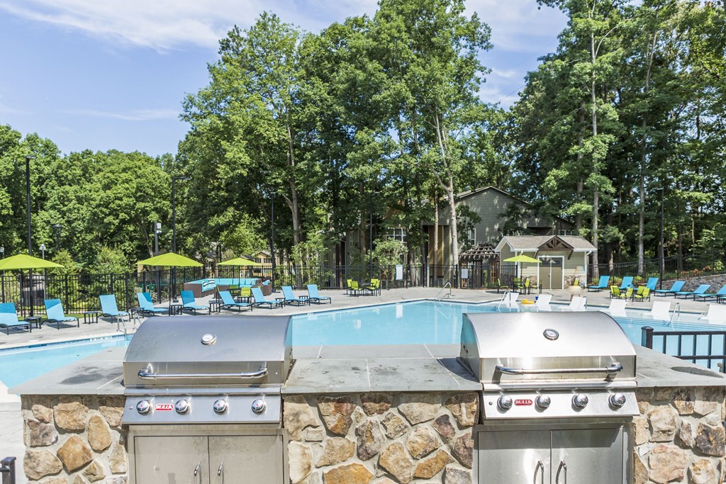 a swimming pool with two grills next to a resort pool