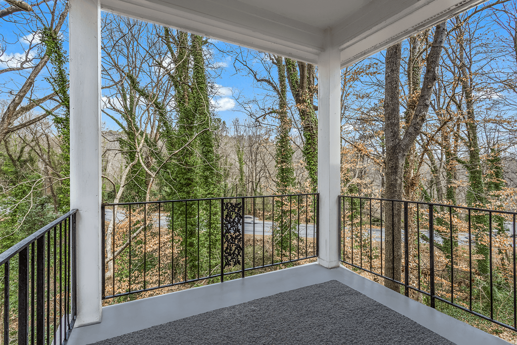 a balcony with a view of trees and a river