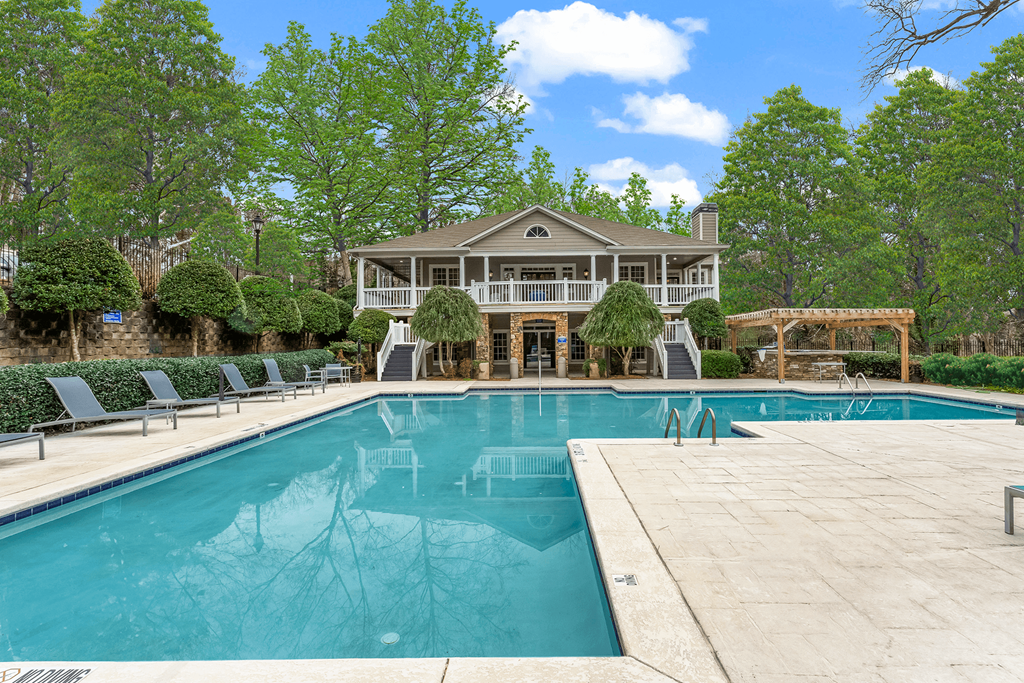 a large pool with a house in the background