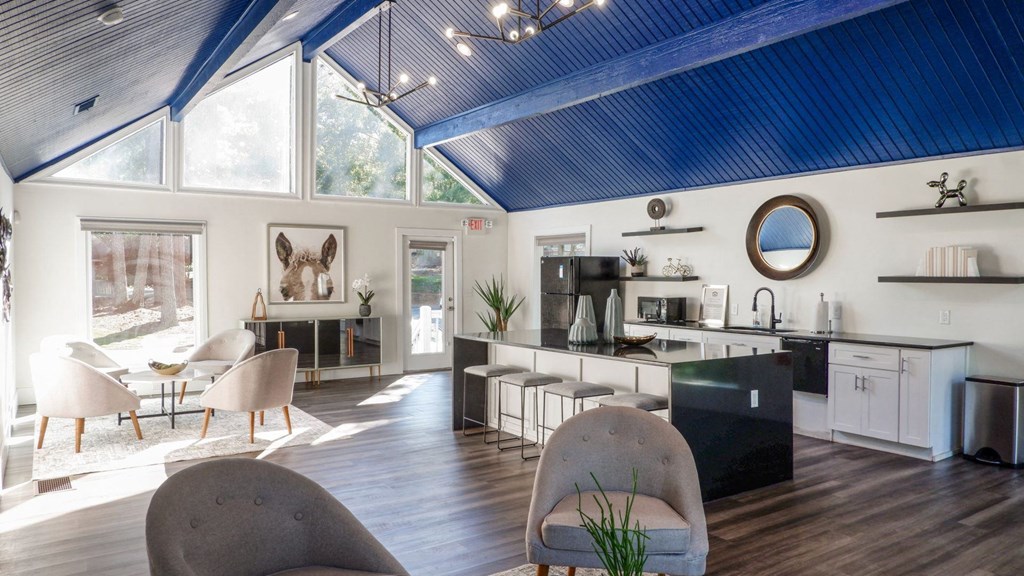 a living room with a kitchen and a blue ceiling