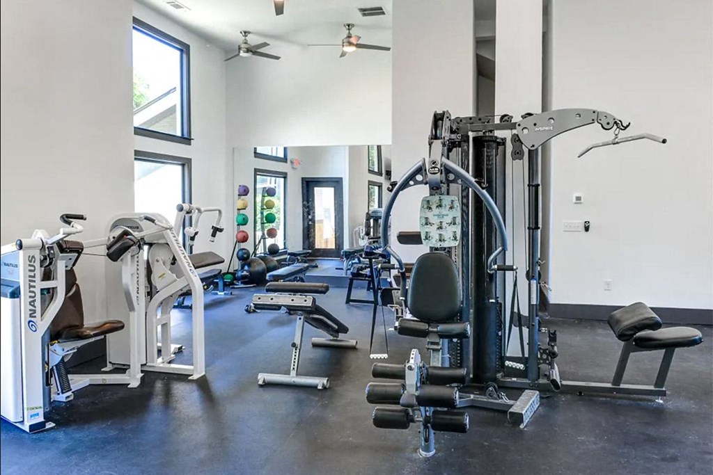 a gym with weights and cardio equipment in a building