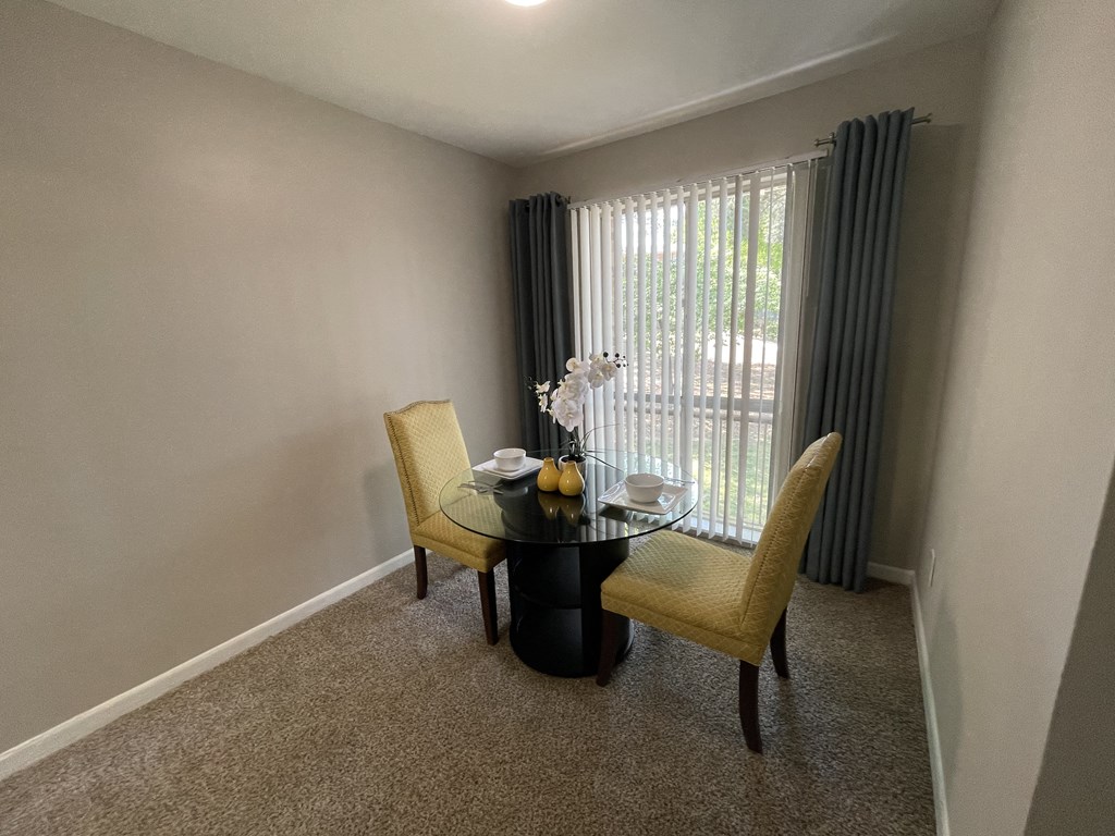 a dining room with a table and chairs and a window