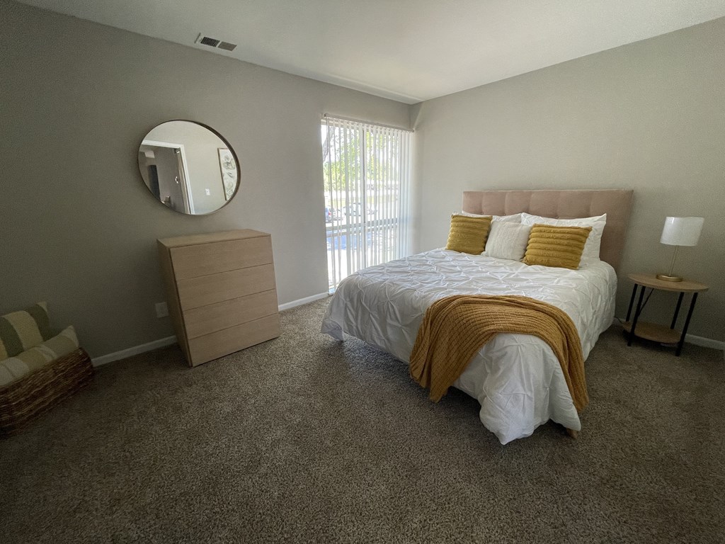 a bedroom with a bed and a dresser and a window