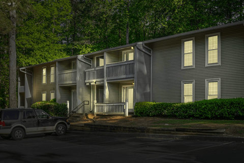 A car is parked in front of a two-story house.