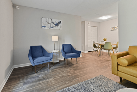 A living room with blue chairs and a yellow couch.