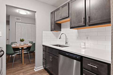 A modern kitchen with dark wood cabinets and a stainless steel dishwasher.