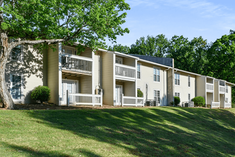 A row of apartment buildings with green trees in the background.