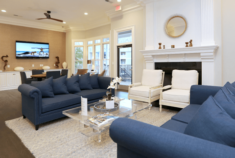 A living room with a blue couch and a white chair.