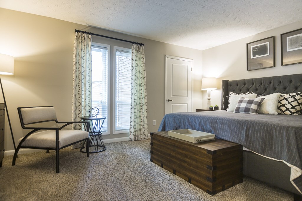 a bedroom with a bed and a chair and a table