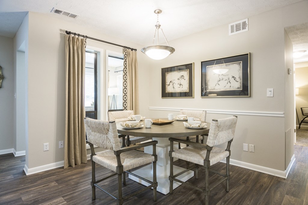 a dining room with a table and chairs and a window