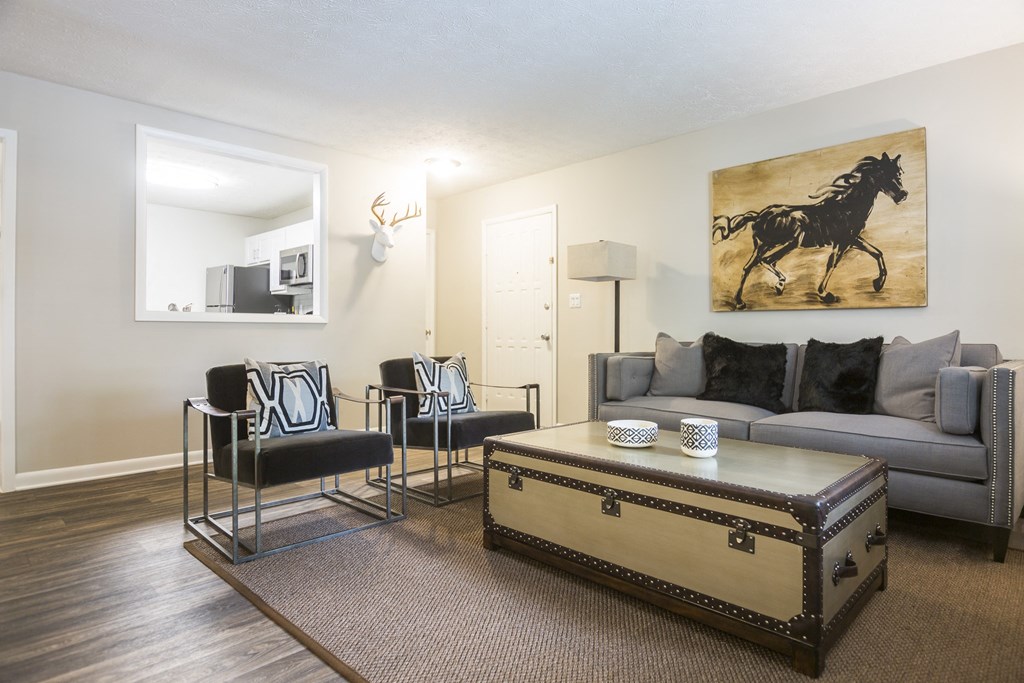 a living room with a couch and chairs and a coffee table