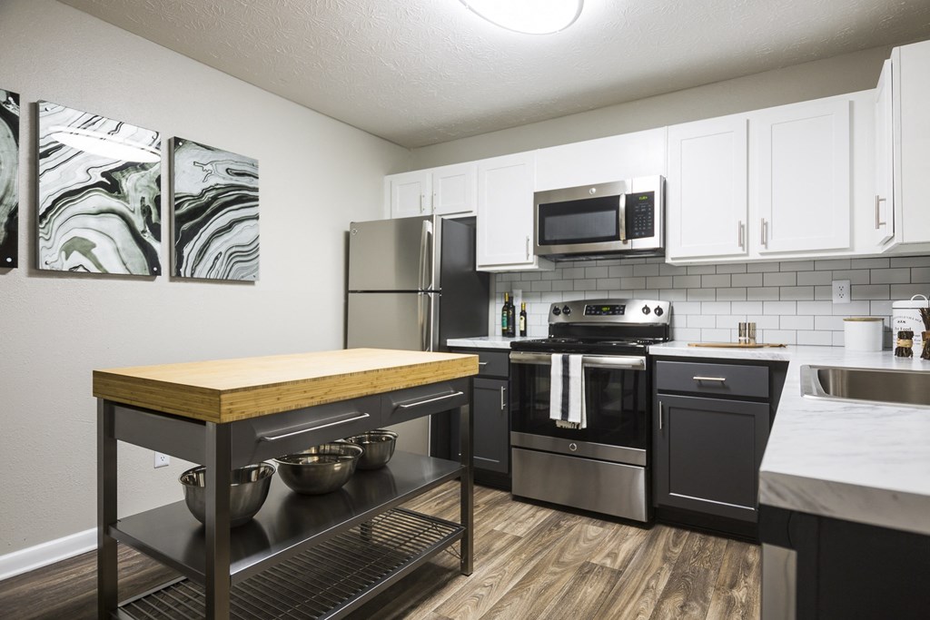 a kitchen with stainless steel appliances and a wooden island with a counter top