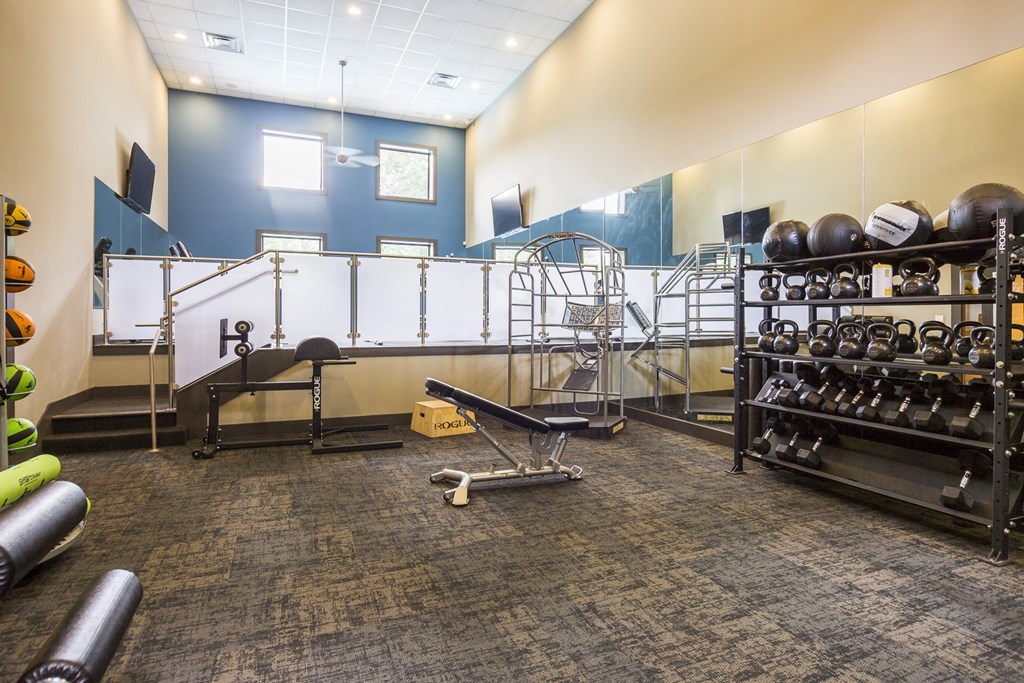 a fitness room with weights and a rack of dumbbells