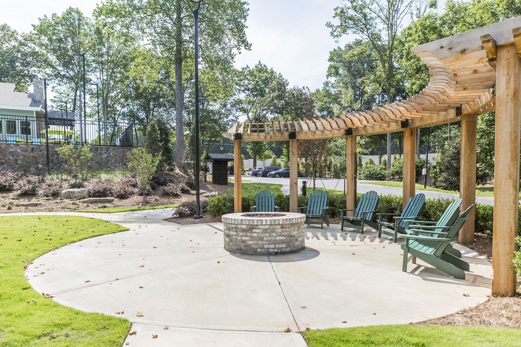 a patio with chairs and a fire pit