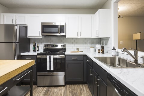 a kitchen with stainless steel appliances and white cabinets