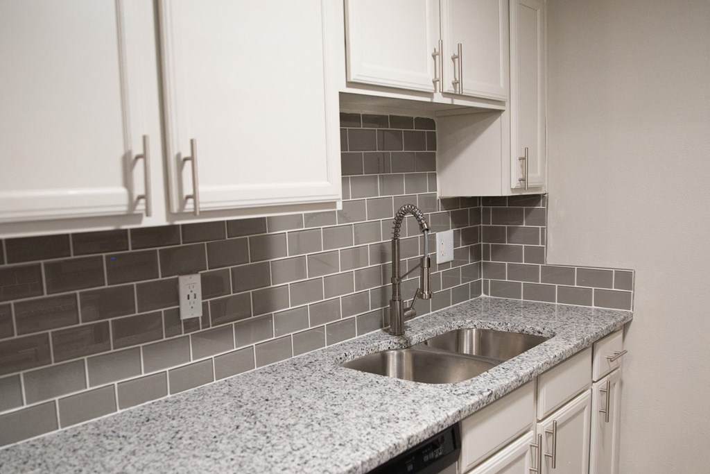 a kitchen with white cabinets and a sink
