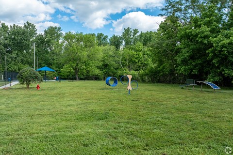 A playground with a blue umbrella and a red fire hydrant.