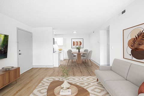 A living room with a grey couch, a wooden coffee table, and a painting on the wall.